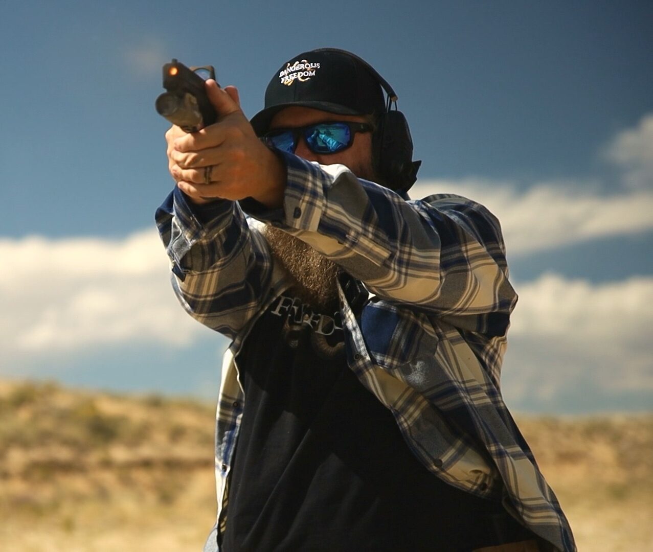 Shawn Herrin firing a handgun during an outdoor range drill